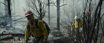 Movie still from “Only the Brave” (2017), directed by Joseph Kosinski – A couple of people that are walking through the woods; Medium shot, Low angle