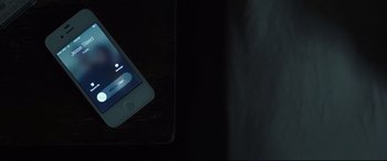 Movie still from “Only the Brave” (2017), directed by Joseph Kosinski – An iphone is sitting on a table in the dark; Extreme Close Up shot, Overhead angle
