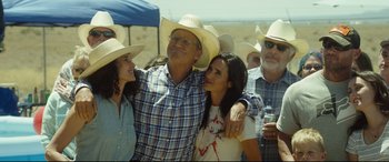 Movie still from “Only the Brave” (2017), directed by Joseph Kosinski – A group of people standing next to each other wearing cowboy hats; Medium shot, Over the shoulder angle