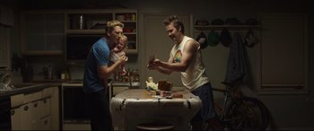 Movie still from “Only the Brave” (2017), directed by Joseph Kosinski – A group of men standing around a table in a kitchen; Medium shot, Low angle