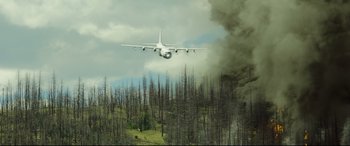 Movie still from “Only the Brave” (2017), directed by Joseph Kosinski – An airplane flying low over a burned forest; Extreme Wide shot, Low angle