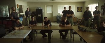 Movie still from “Only the Brave” (2017), directed by Joseph Kosinski – A group of men sitting at a table in a room; Wide shot, Over the shoulder angle