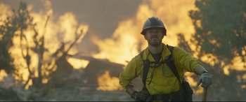 Movie still from “Only the Brave” (2017), directed by Joseph Kosinski – A man in a yellow shirt wearing a helmet; Medium shot, Low angle