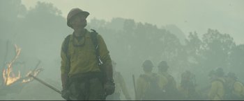 Movie still from “Only the Brave” (2017), directed by Joseph Kosinski – A group of men standing on top of a forest; Medium shot, Low angle