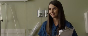 Movie still from “Only the Brave” (2017), directed by Joseph Kosinski – A female doctor smiling for the camera in a hospital room; Close Up shot, Over the shoulder angle