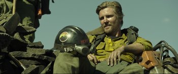 Movie still from “Only the Brave” (2017), directed by Joseph Kosinski – A man sitting on the ground with a helmet on his head; Medium shot, Low angle
