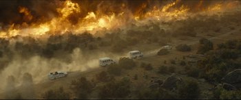 Movie still from “Only the Brave” (2017), directed by Joseph Kosinski – A group of buses traveling down a dirt road near a forest fire; Extreme Wide shot, High angle