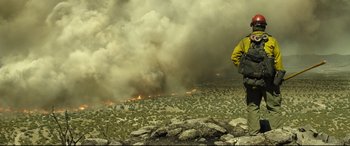 Movie still from “Only the Brave” (2017), directed by Joseph Kosinski – A man standing on top of a rocky hill; Wide shot, Low angle