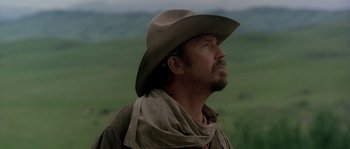 Movie still from “Open Range” (2003), directed by Kevin Costner – A man wearing a cowboy hat looking up into the sky; Close Up shot, Low angle