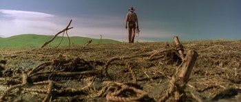 Movie still from “Open Range” (2003), directed by Kevin Costner – A man in a cowboy hat is standing in a field; Extreme Wide shot, Low angle