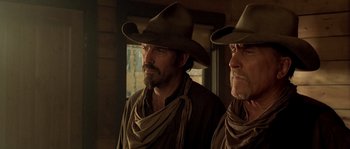 Movie still from “Open Range” (2003), directed by Kevin Costner – Two men in cowboy hats and a brown jacket; Close Up shot, Low angle