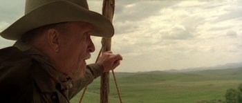 Movie still from “Open Range” (2003), directed by Kevin Costner – An older man in a cowboy hat holding a rope; Close Up shot, Low angle