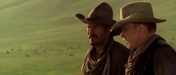 Movie still from “Open Range” (2003), directed by Kevin Costner – Two men in cowboy hats and a brown scarf; Close Up shot, Low angle