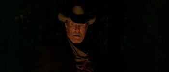 Movie still from “Open Range” (2003), directed by Kevin Costner – A man in a cowboy hat is looking at the camera; Close Up shot, Low angle