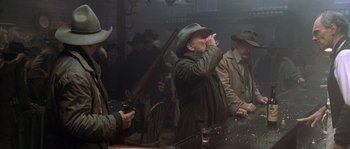 Movie still from “Open Range” (2003), directed by Kevin Costner – A group of men standing next to each other in a room; Medium shot, Low angle