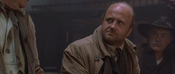 Movie still from “Open Range” (2003), directed by Kevin Costner – A man in a brown jacket and a tie; Close Up shot, Low angle