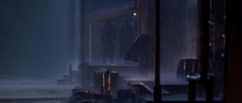 Movie still from “Open Range” (2003), directed by Kevin Costner – Two men are walking in the rain with an open umbrella; Wide shot, Low angle