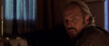 Movie still from “Open Range” (2003), directed by Kevin Costner – A person with a beard looking at the camera; Close Up shot, Over the shoulder angle