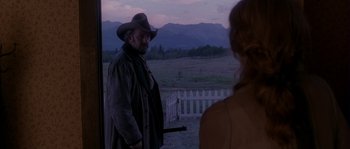 Movie still from “Open Range” (2003), directed by Kevin Costner – A man in a cowboy hat standing next to a woman in a cowboy hat; Medium shot, Over the shoulder angle