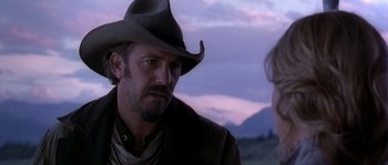 Movie still from “Open Range” (2003), directed by Kevin Costner – A man wearing a cowboy hat talking to a woman; Close Up shot, Over the shoulder angle
