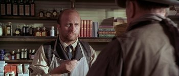 Movie still from “Open Range” (2003), directed by Kevin Costner – A man wearing an apron talking to another man in an apron; Medium shot, Over the shoulder angle