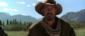 Movie still from “Open Range” (2003), directed by Kevin Costner – A man wearing a cowboy hat in a field; Close Up shot, Low angle