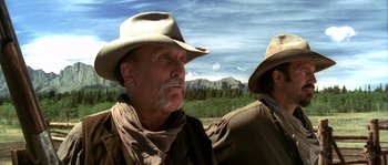 Movie still from “Open Range” (2003), directed by Kevin Costner – A man in a cowboy hat and a man in a cowboy outfit; Close Up shot, Low angle
