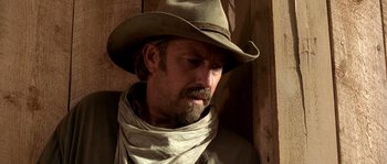 Movie still from “Open Range” (2003), directed by Kevin Costner – A man wearing a cowboy hat and a neck scarf; Close Up shot, Over the shoulder angle