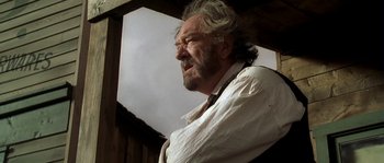 Movie still from “Open Range” (2003), directed by Kevin Costner – An old man with a beard and a white shirt; Close Up shot, Low angle