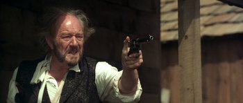 Movie still from “Open Range” (2003), directed by Kevin Costner – An older man holding a gun in his right hand; Close Up shot, Low angle
