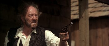 Movie still from “Open Range” (2003), directed by Kevin Costner – An older man holding a gun in his right hand; Close Up shot, Low angle