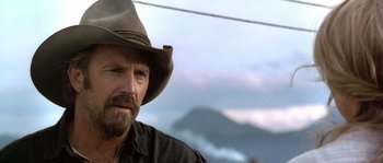 Movie still from “Open Range” (2003), directed by Kevin Costner – A man with a beard and a cowboy hat; Close Up shot, Over the shoulder angle