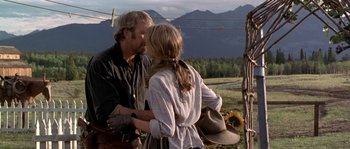 Movie still from “Open Range” (2003), directed by Kevin Costner – A man and a woman standing next to each other in a field; Medium shot, Over the shoulder angle