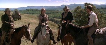 Movie still from “Open Range” (2003), directed by Kevin Costner – A man and a woman riding horses in a field; Wide shot, Low angle