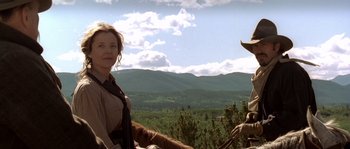 Movie still from “Open Range” (2003), directed by Kevin Costner – A woman standing next to a horse in a field; Medium shot, Low angle