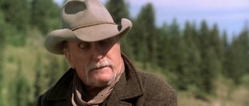 Movie still from “Open Range” (2003), directed by Kevin Costner – An older man with a hat and a beard; Close Up shot, Low angle