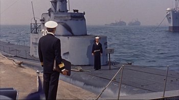 Movie still from “Operation Petticoat” (1959), directed by Blake Edwards – Two men standing on the deck of a boat; Wide shot, Over the shoulder angle