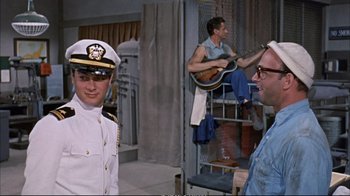 Movie still from “Operation Petticoat” (1959), directed by Blake Edwards – Two men in uniform are standing in a room; Medium shot, Over the shoulder angle