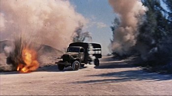 Movie still from “Operation Petticoat” (1959), directed by Blake Edwards – An old military truck driving down a dirt road; Extreme Wide shot, High angle