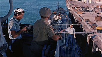 Movie still from “Operation Petticoat” (1959), directed by Blake Edwards – A group of men standing on the deck of a boat; Wide shot, High angle
