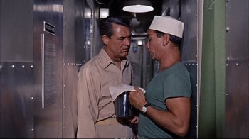 Movie still from “Operation Petticoat” (1959), directed by Blake Edwards – Two men are talking in a train car; Medium shot, Over the shoulder angle
