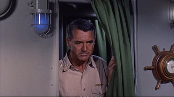 Movie still from “Operation Petticoat” (1959), directed by Blake Edwards – A man that is standing in a train car; Medium shot, High angle