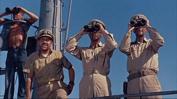Movie still from “Operation Petticoat” (1959), directed by Blake Edwards – A group of men standing next to each other on a boat; Medium shot, Low angle