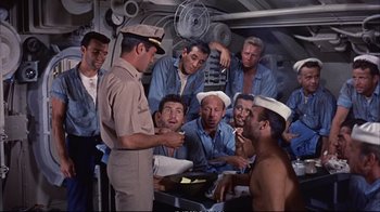 Movie still from “Operation Petticoat” (1959), directed by Blake Edwards – A group of men standing in a room; Medium shot, High angle