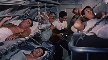Movie still from “Operation Petticoat” (1959), directed by Blake Edwards – A group of men are sleeping in a room; Wide shot, High angle