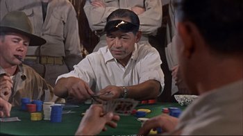 Movie still from “Operation Petticoat” (1959), directed by Blake Edwards – A man in a white shirt is playing a game of poker; Close Up shot, Over the shoulder angle