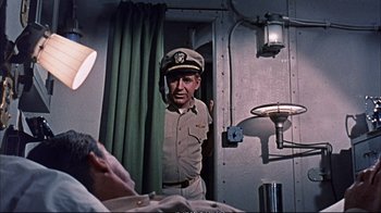 Movie still from “Operation Petticoat” (1959), directed by Blake Edwards – An old photo of a man in a uniform looking out of a window; Medium shot, Over the shoulder angle
