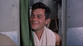 Movie still from “Operation Petticoat” (1959), directed by Blake Edwards – A man with a towel around his neck looking out a window; Close Up shot, Low angle