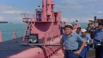 Movie still from “Operation Petticoat” (1959), directed by Blake Edwards – A man standing on the side of a pink boat; Medium shot, High angle