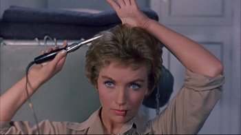 Movie still from “Operation Petticoat” (1959), directed by Blake Edwards – A person cutting their hair; Close Up shot, Low angle